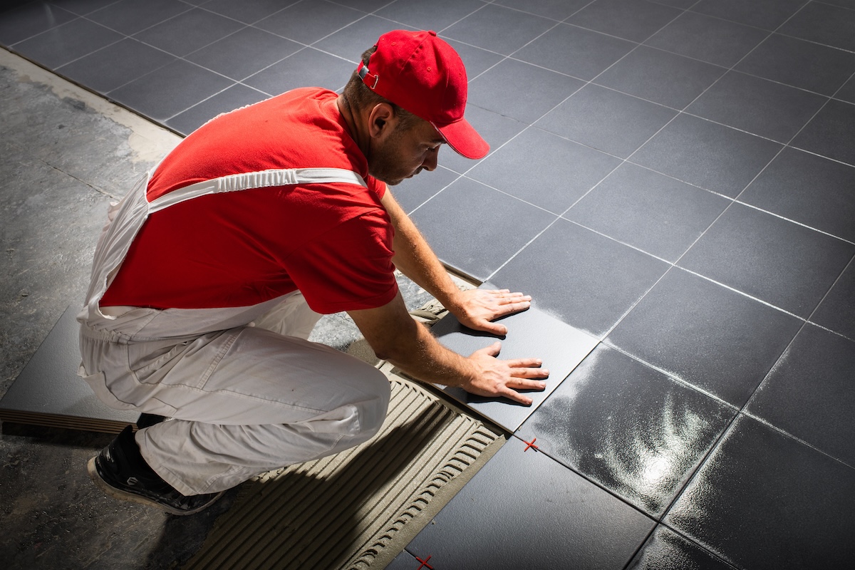 a person installing floor, fresh cement